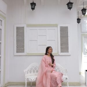 Woman wearing a light pink embroidered kurta with matching dupatta and floral detailing