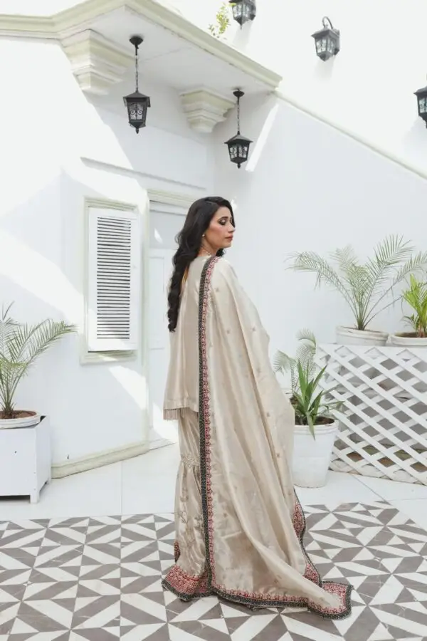 Champagne-gold bridal dress in silk tissue with fully hand-embroidered shirt and garara, handmade sleeve hangings, and zari tissue dupatta with velvet embroidered borders.