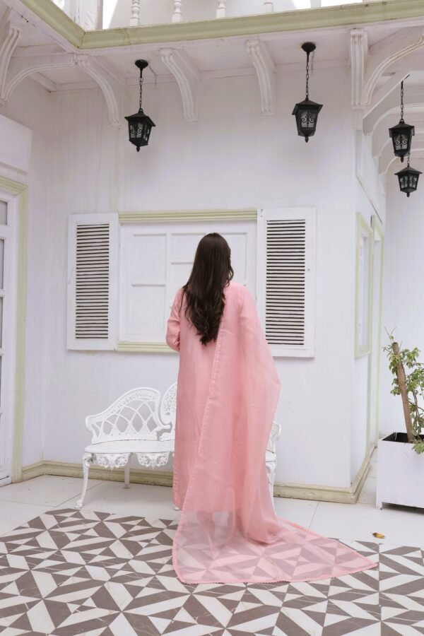 Woman wearing a light pink embroidered kurta with matching dupatta and floral detailing